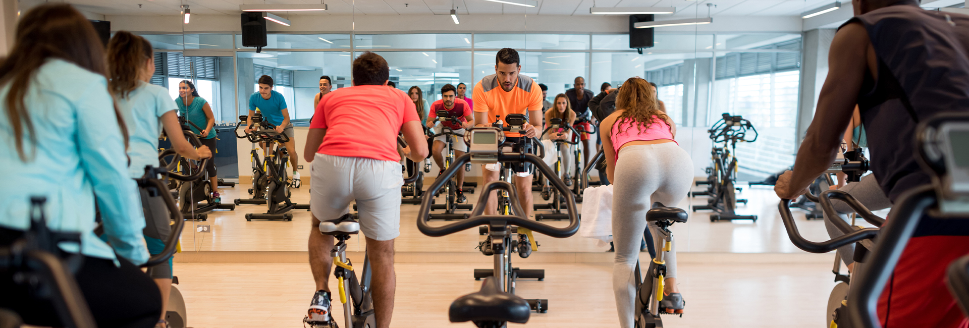 spin instructor leading cycling gym group class